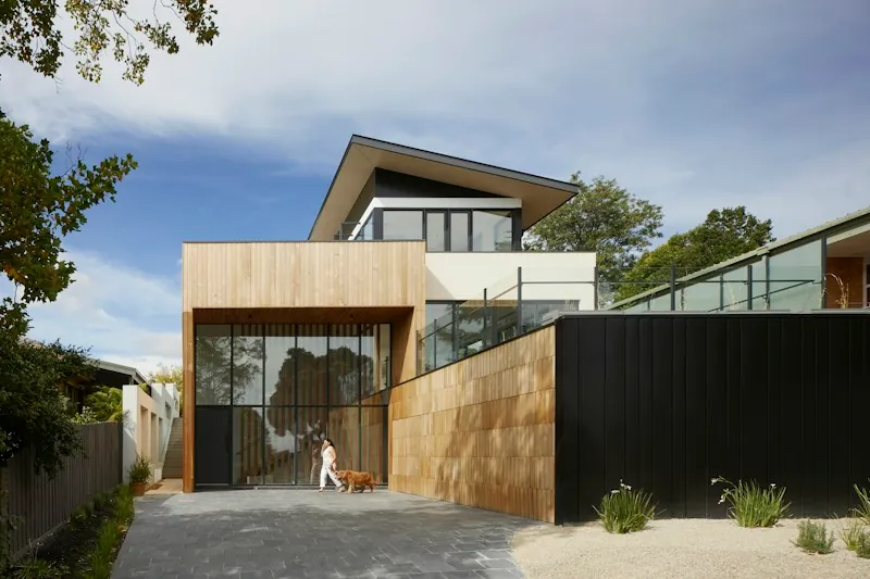 Contemporary home with a glazed upper balcony and timber-clad walls